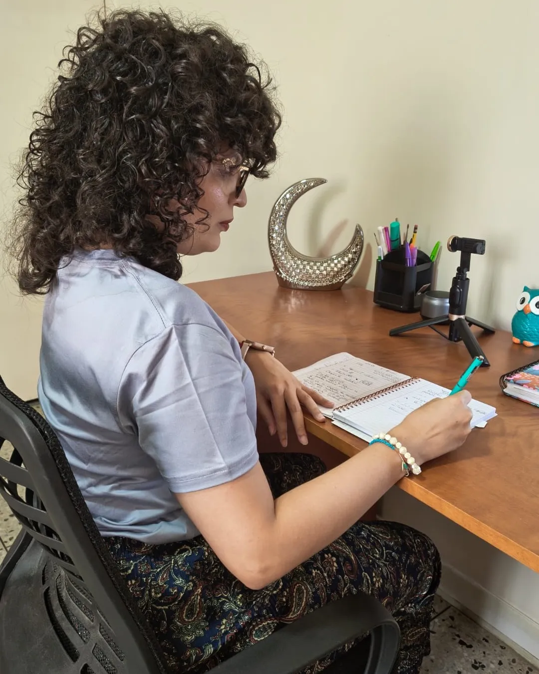 Laimary Linares escribiendo en un cuaderno en su escritorio